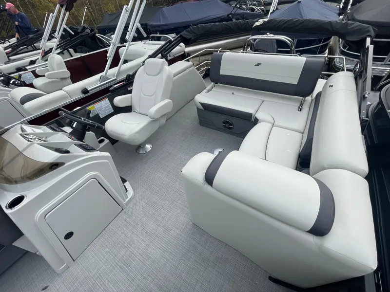 Slide: The Image of 2024 Starcraft EXS 3Q pontoon boat interior with white seating and captain's chair. - 12