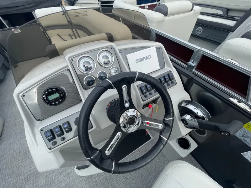Slide: The Image of 2024 Starcraft EXS 3Q boat dashboard with steering wheel, gauges, and Simrad display. - 13