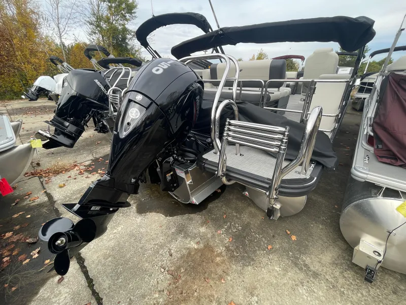 Slide: The Image of 2024 Starcraft EXS 3Q pontoon boat with outboard motor, docked on a concrete surface. - 5