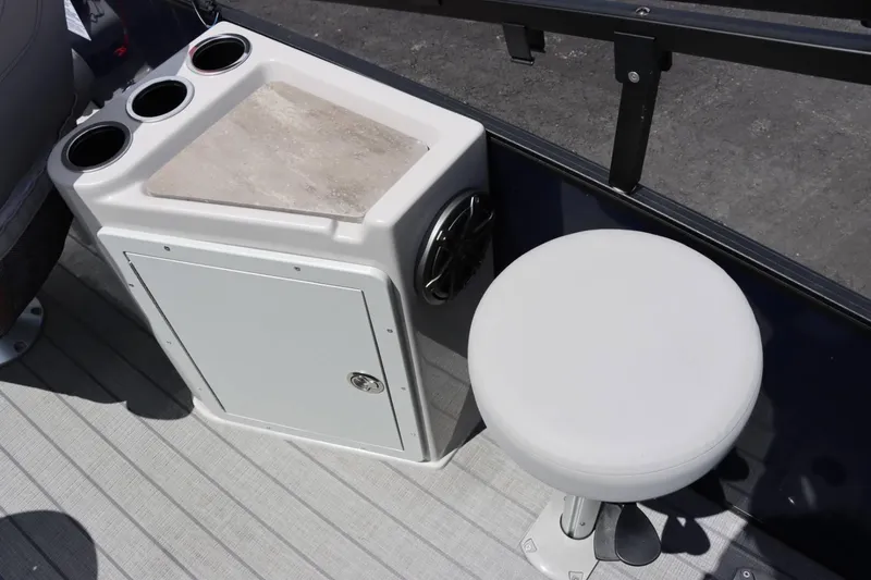 Slide: The Image of 2023 Starcraft CX 23DL Bar boat interior with stool, storage, and cup holders. - 10