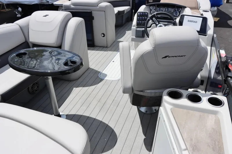Slide: The Image of 2023 Starcraft CX 23DL Bar boat interior with seating, table, and control console. - 9