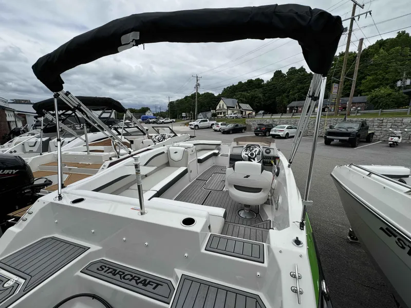 Slide: The Image of 2024 Starcraft SVX 191 OB boat with canopy, docked in a marina. - 13