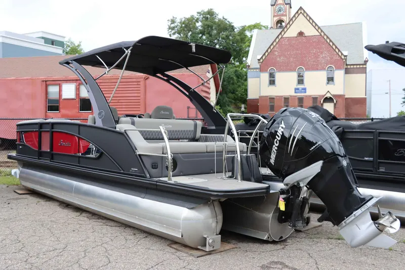 Slide: The Image of 2023 Barletta Lusso 23UCA pontoon boat with Mercury engine, parked near a historic building. - 1