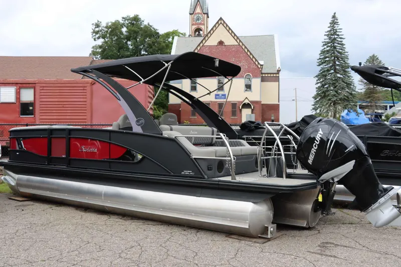 Slide: The Image of 2023 Barletta Lusso 23UCA pontoon boat with Mercury engine, parked outdoors. - 2
