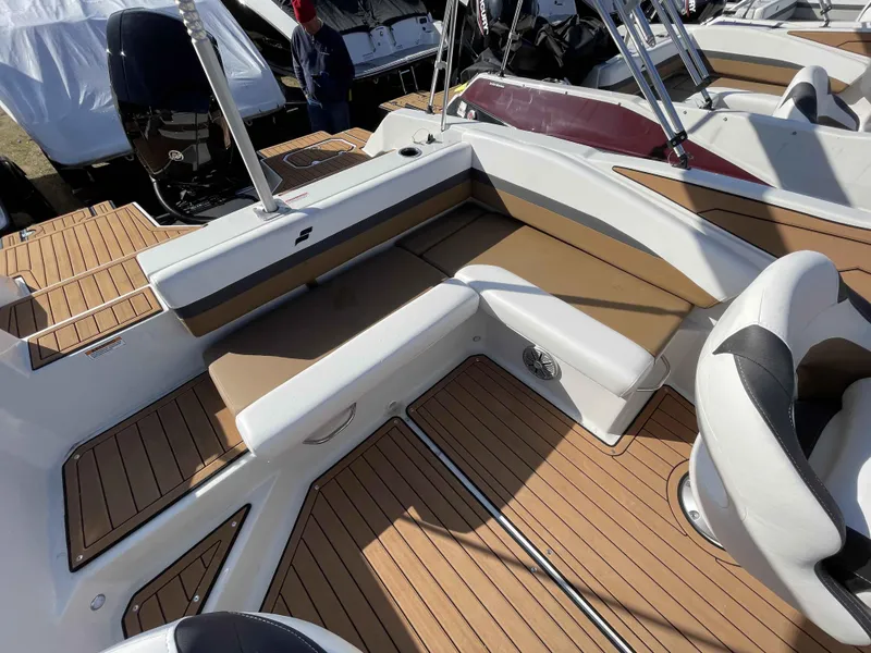 Slide: The Image of 2023 Starcraft SVX 210 OB boat interior with tan and white seating and wood-like flooring. - 12