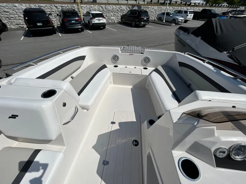 Slide: The Image of 2023 Starcraft SVX 171 OB boat interior with seating and cup holders in a parking lot. - 6