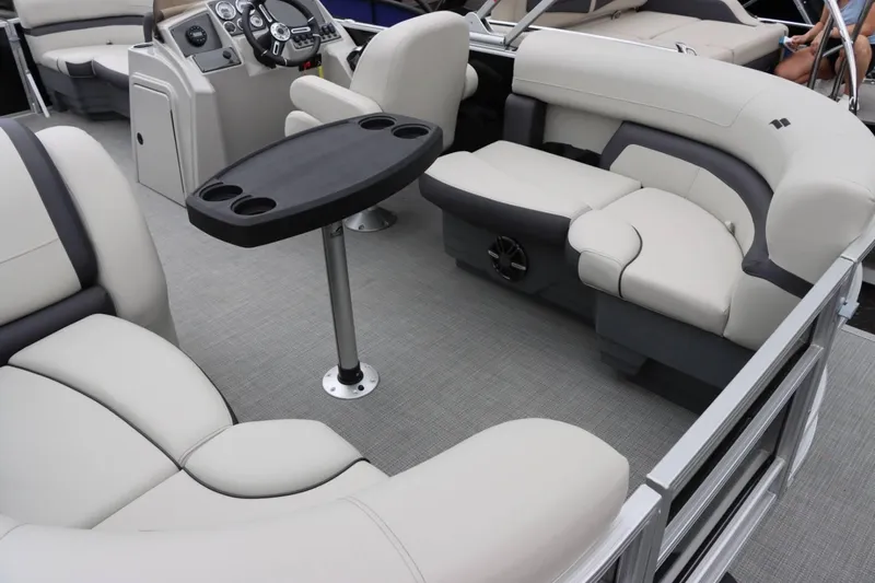 Slide: The Image of 2024 Starcraft EX 20R pontoon boat interior with plush seating and a central table. - 13