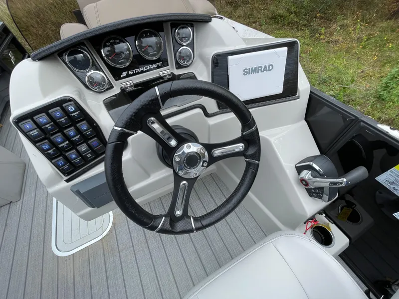 Slide: The Image of 2023 Starcraft CX 25DL BAR boat dashboard with steering wheel and control panel. - 9