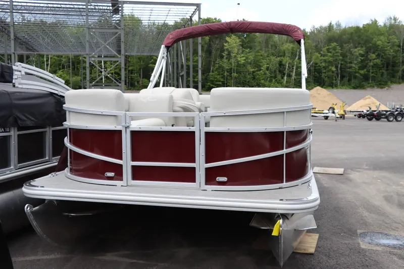 Slide: The Image of 2024 SunChaser VISTA 18LR pontoon boat with maroon and white exterior, parked outdoors. - 8