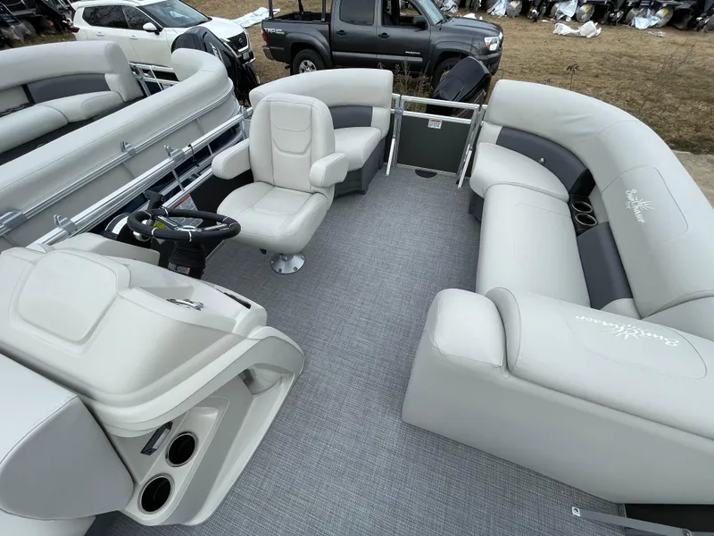 Slide: The Image of 2024 SunChaser VISTA 18LR pontoon boat interior with plush seating and steering console. - 5