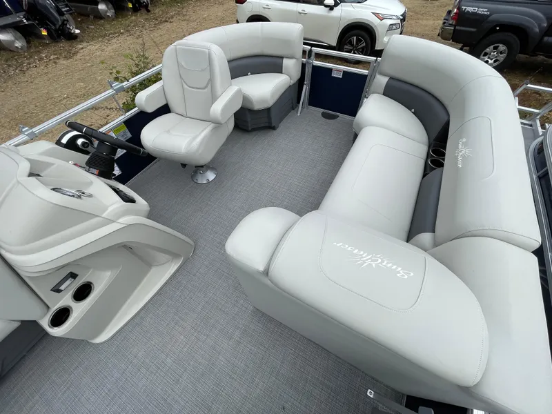 Slide: The Image of 2024 SunChaser VISTA 18LR pontoon boat interior with plush seating and steering console. - 5