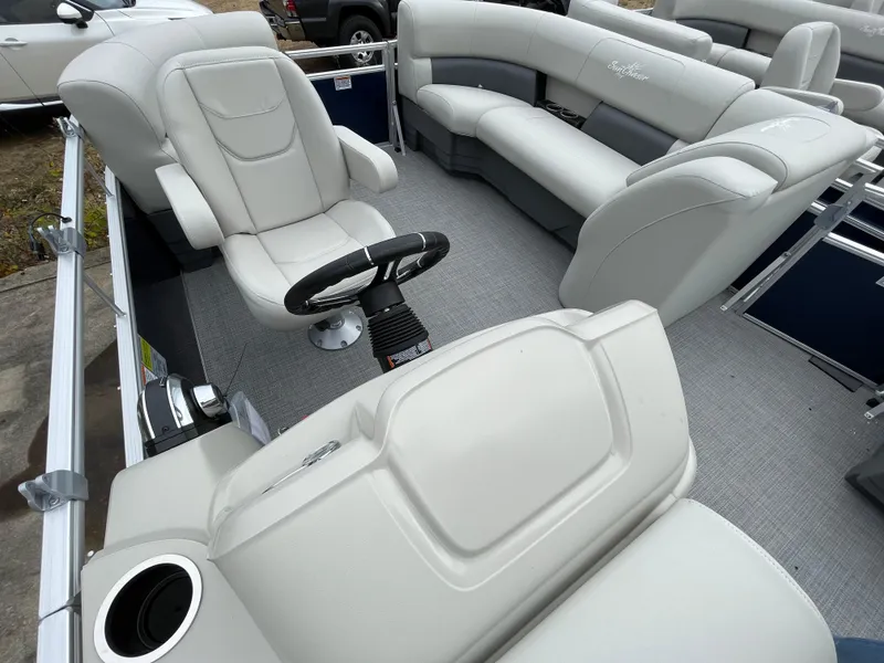 Slide: The Image of 2024 SunChaser VISTA 18LR pontoon boat interior with plush seating and steering console. - 7