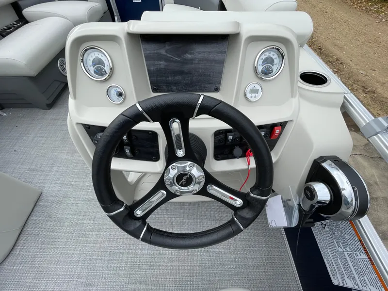Slide: The Image of 2024 SunChaser VISTA 18LR boat dashboard with steering wheel and control panel. - 9