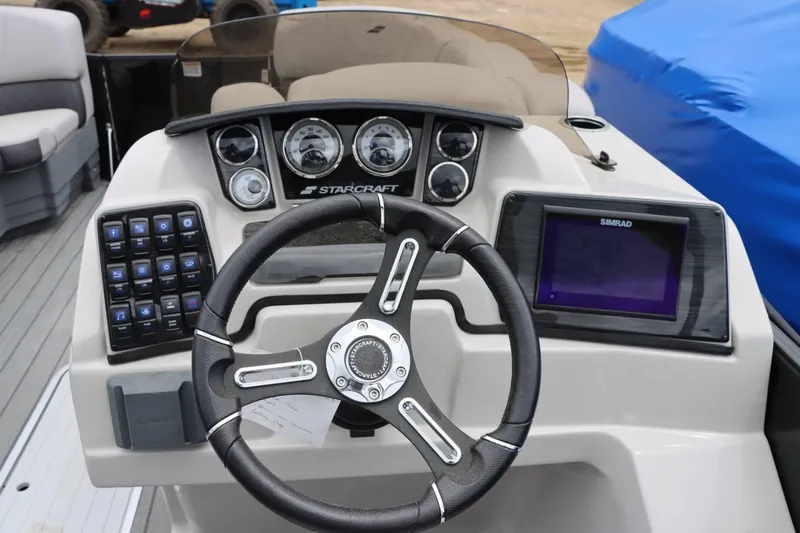 Slide: The Image of 2023 Starcraft SLS 3 boat dashboard with steering wheel, gauges, and Simrad display. - 14