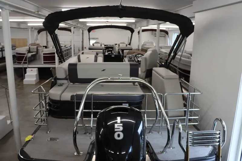 Slide: The Image of 2023 Starcraft EXS 3Q pontoon boat in showroom, featuring a 150 HP engine. - 26