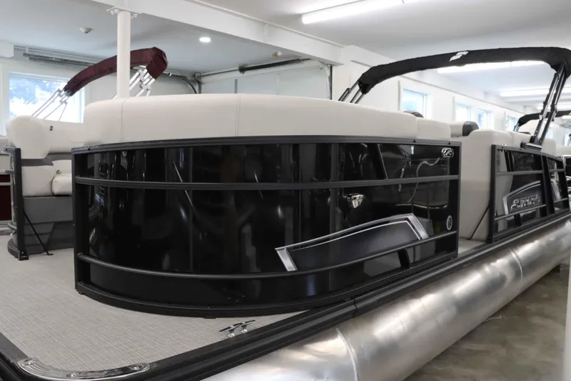 Slide: The Image of 2023 Starcraft EXS 3Q pontoon boat in showroom, featuring sleek black design and comfortable seating. - 3