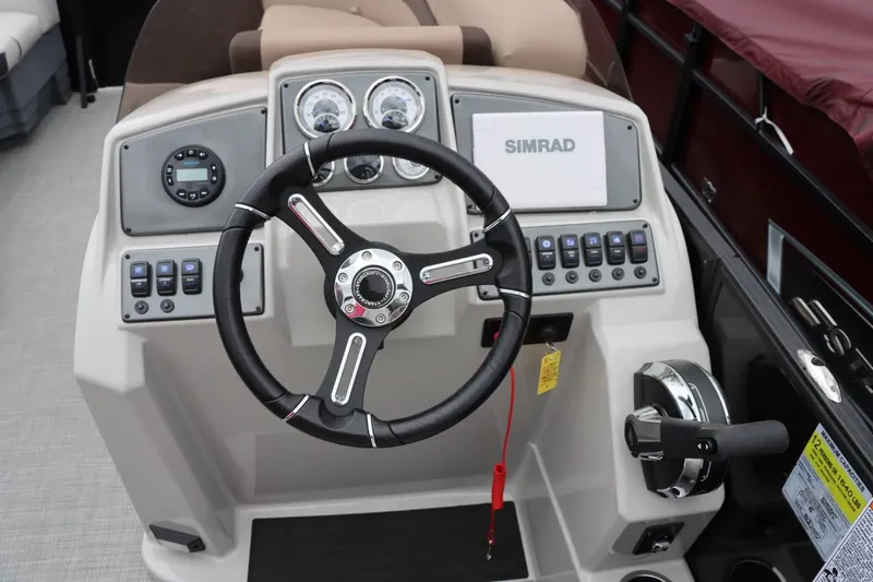 Slide: The Image of 2024 Starcraft EXS 3 boat dashboard with steering wheel, Simrad display, and control panel. - 12