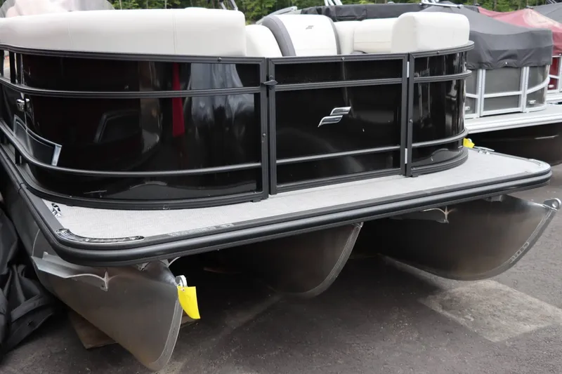 Slide: The Image of 2024 Starcraft EXS 3 pontoon boat rear view with black exterior and white seating. - 3