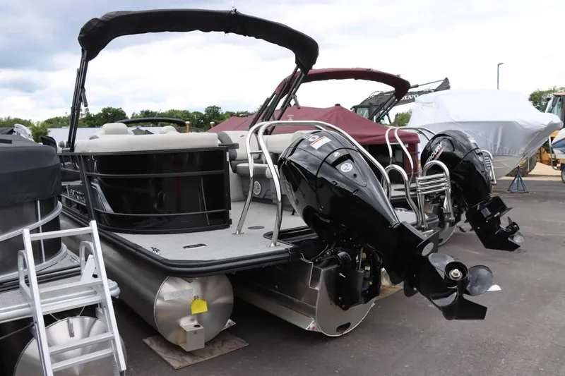 Slide: The Image of 2024 Starcraft EXS 3 pontoon boat with dual outboard motors in a marina. - 5