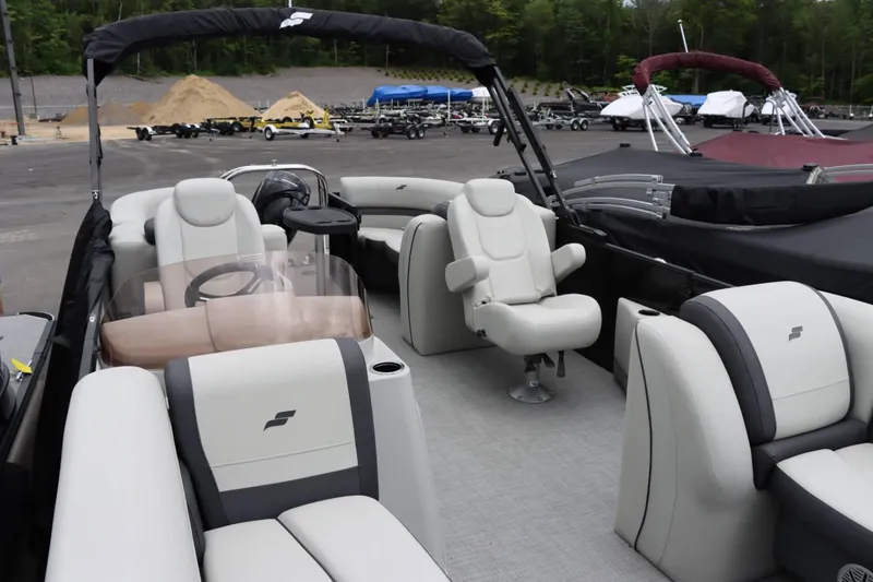 Slide: The Image of 2024 Starcraft EXS 3 pontoon boat interior with plush seating and steering console. - 6
