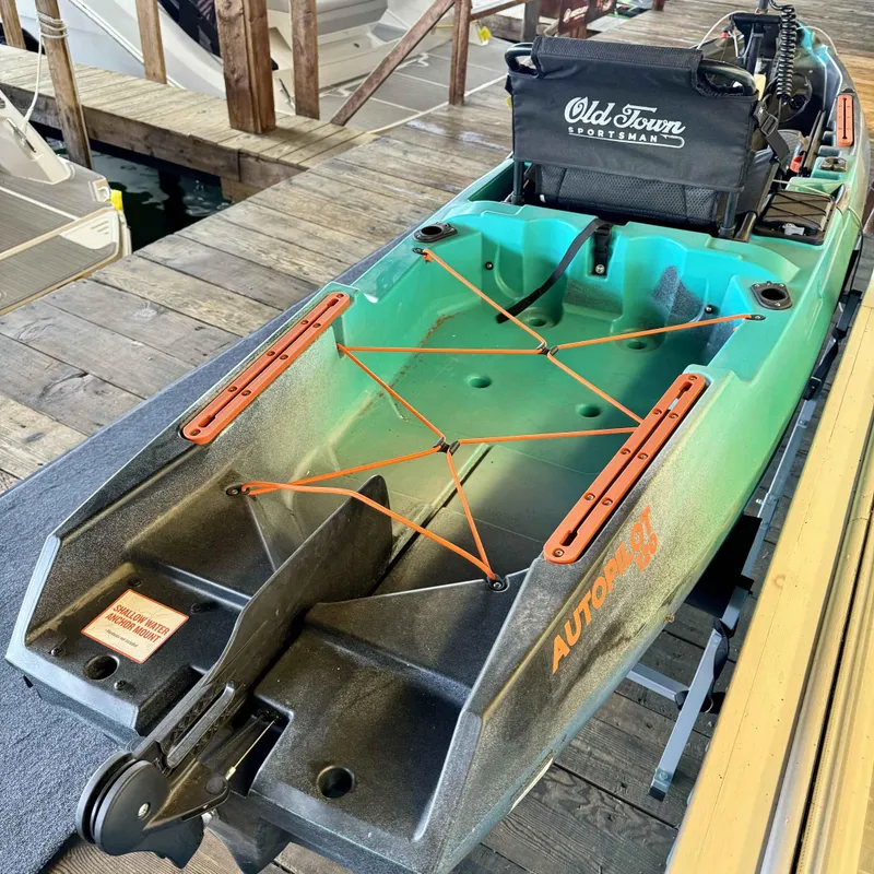 Slide: The Image of 2023 Old Town Sportsman 120 Autopilot kayak docked, featuring a comfortable seat and storage area. - 3