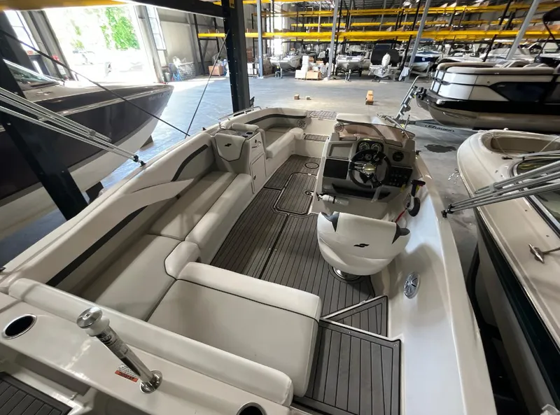 Slide: The Image of 2023 Starcraft SVX 191 OB boat interior with seating and steering console in a storage facility. - 4