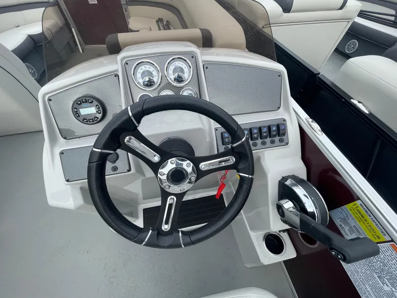 Slide: The Image of 2023 Starcraft EX 22C boat dashboard with steering wheel and control panel. - 14