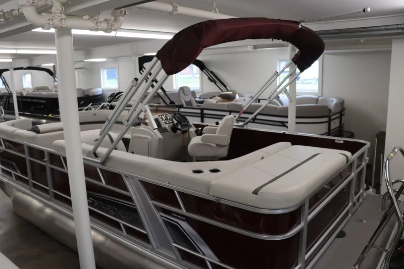 Slide: The Image of 2023 Starcraft EX 22C pontoon boat in showroom, featuring sleek design and comfortable seating. - 2