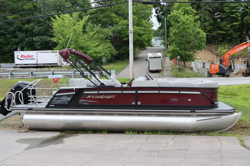Slide: The Image of 2023 Starcraft CX 23Q DH pontoon boat parked on pavement near construction site. - 1