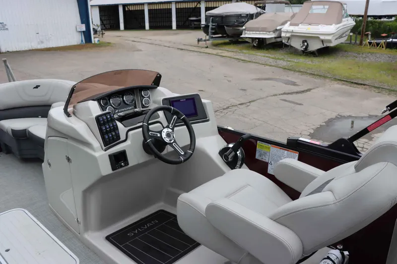 Slide: The Image of 2023 Starcraft CX 23Q DH boat interior with steering console and seating. - 11