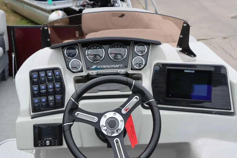 Slide: The Image of 2023 Starcraft CX 23Q DH boat dashboard with steering wheel, gauges, and Simrad display. - 12