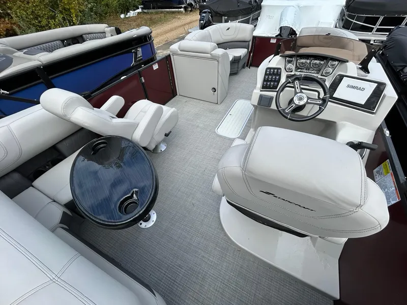 Slide: The Image of 2023 Starcraft CX 23Q DH pontoon boat interior with helm, seating, and table. - 25