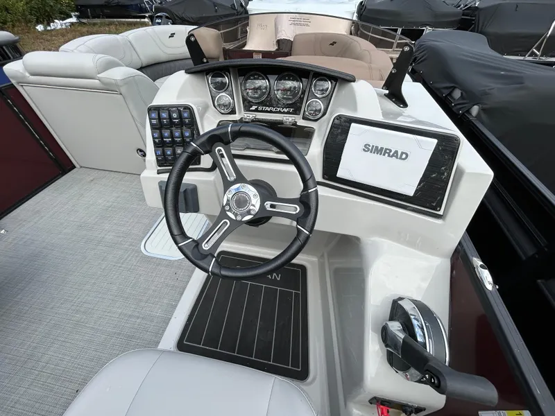 Slide: The Image of 2023 Starcraft CX 23Q DH boat dashboard with steering wheel and Simrad display. - 26