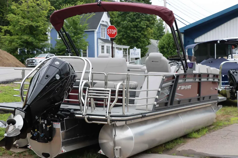 Slide: The Image of 2023 Starcraft CX 23Q DH pontoon boat with outboard motor, parked near a stop sign. - 6