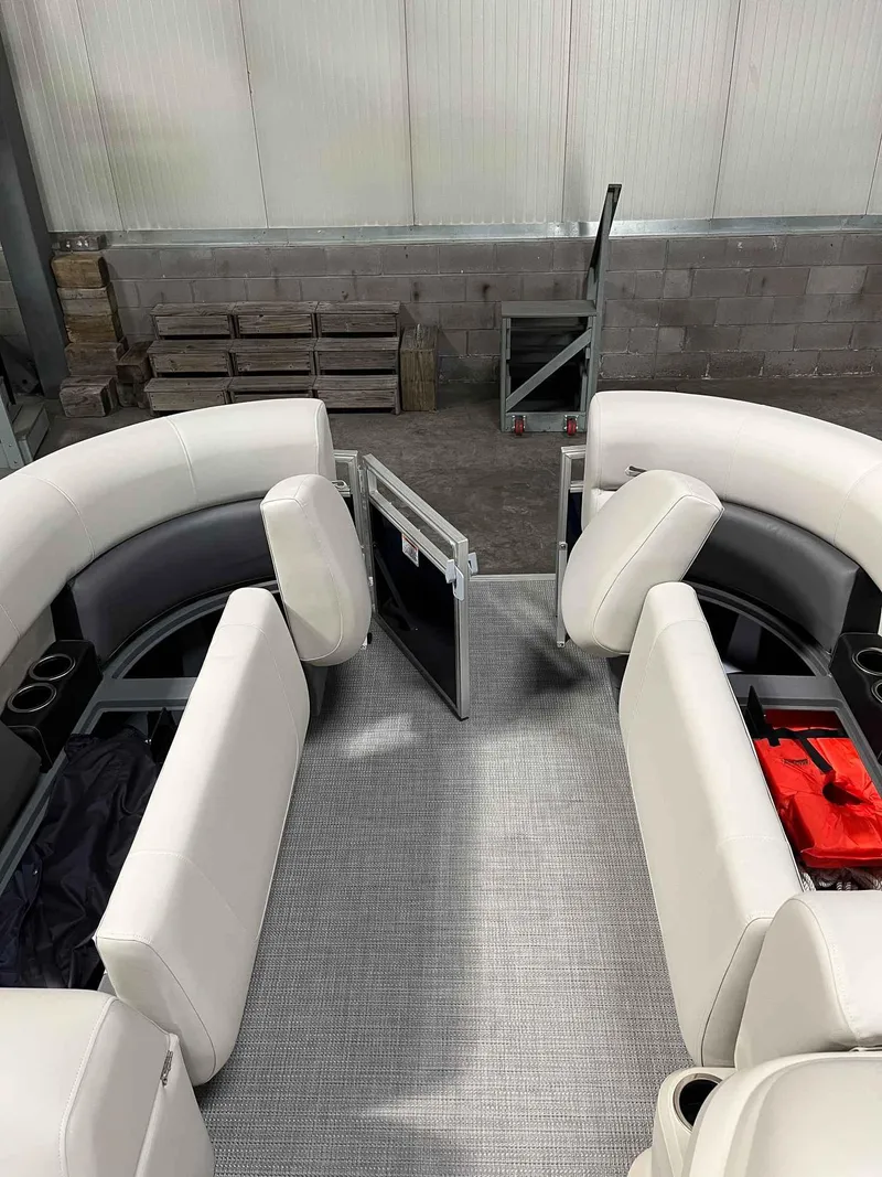 Slide: The Image of 2023 SunChaser VISTA 16LR boat interior with white seating and storage compartments. - 10
