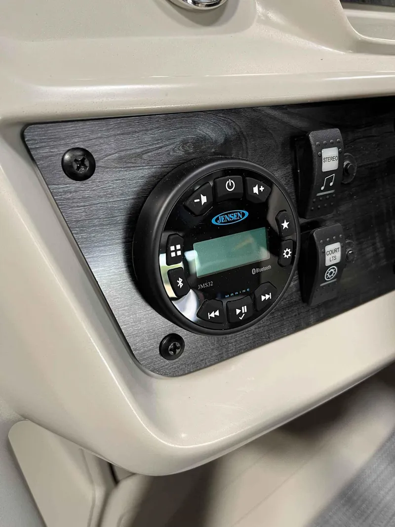 Slide: The Image of 2023 SunChaser VISTA 16LR dashboard with Jensen stereo system and control switches. - 12