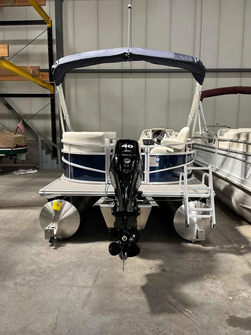 Slide: The Image of 2023 SunChaser VISTA 16LR pontoon boat in warehouse, rear view with motor. - 6