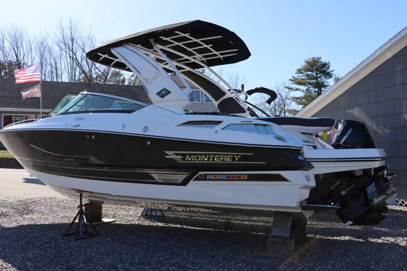 Slide: The Image of 2023 Monterey 298SS boat on stands, black and white exterior, American flag in background. - 5