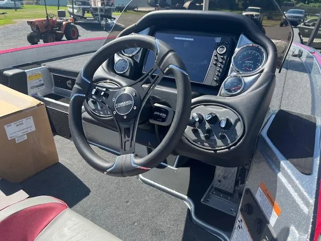 Slide: The Image of 2024 Triton 18 TrX boat dashboard with steering wheel and control panel. - 2