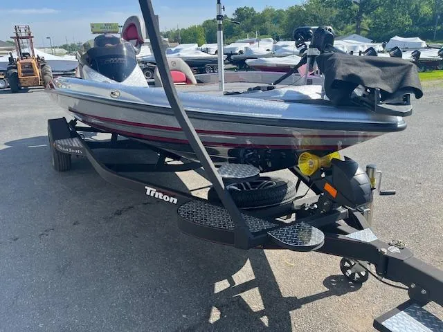 Slide: The Image of 2024 Triton 18 TrX bass boat on trailer in outdoor lot. - 7