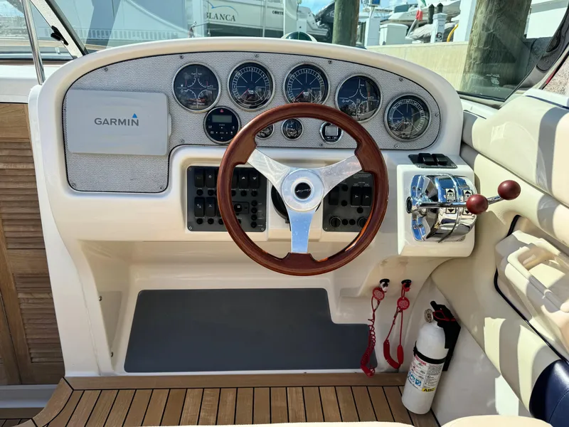 Slide: The Image of 2004 Chris-Craft Corsair 28 boat dashboard with Garmin navigation system and wooden steering wheel. - 19