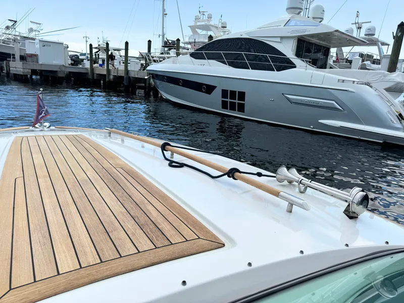 Slide: The Image of 2004 Chris-Craft Corsair 28 docked at a marina with luxury yachts. - 21