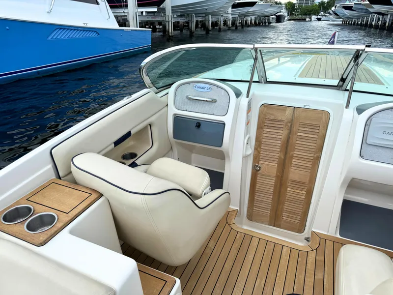 Slide: The Image of 2004 Chris-Craft Corsair 28 boat interior with beige seating and wooden flooring. - 23