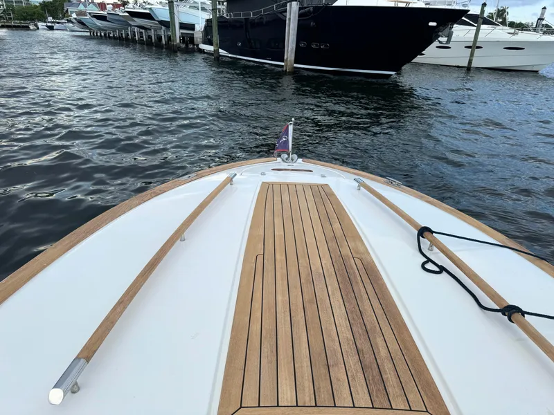 Slide: The Image of 2004 Chris-Craft Corsair 28 boat docked at a marina, featuring a wooden deck. - 24