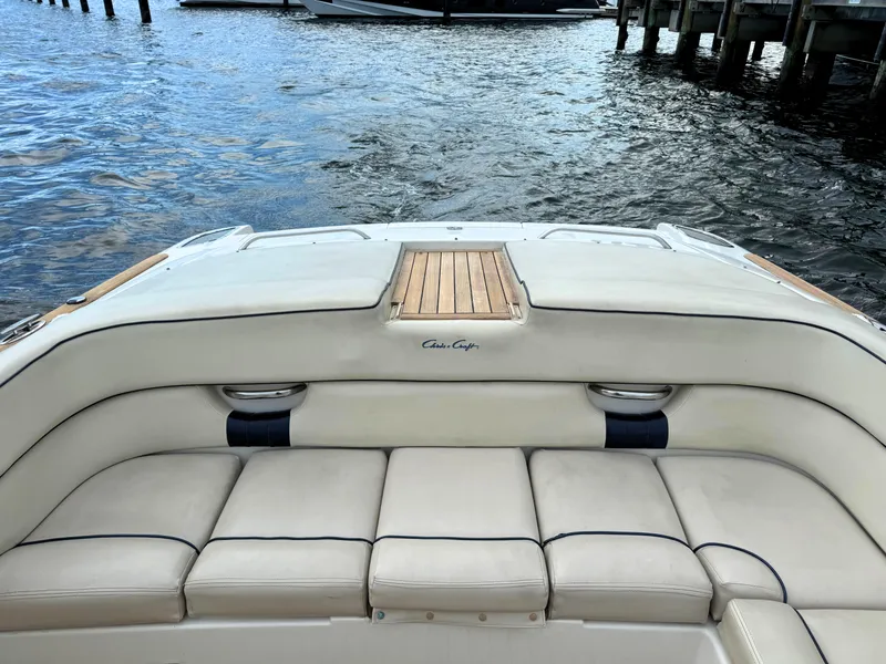 Slide: The Image of 2004 Chris-Craft Corsair 28 boat with cushioned seating and wooden accents on the water. - 25