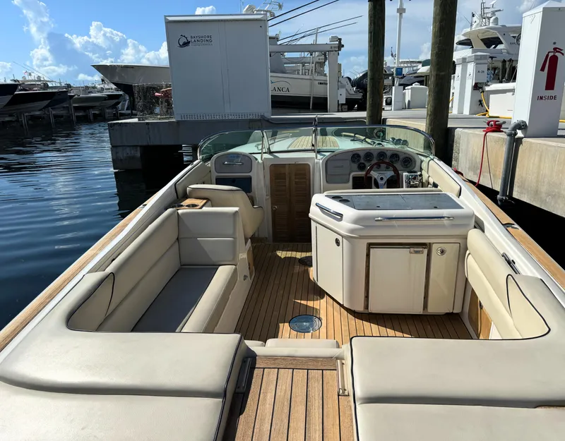 Slide: The Image of 2004 Chris-Craft Corsair 28 boat interior with beige seating and wooden deck. - 28
