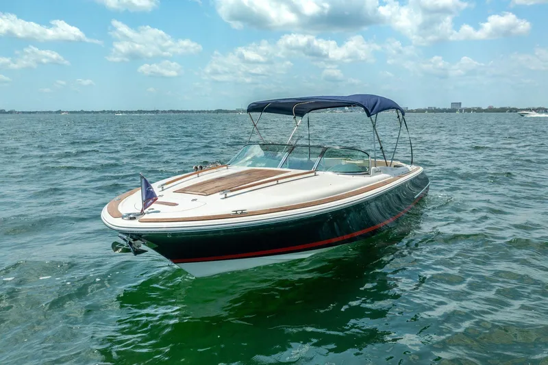 Slide: The Image of 2004 Chris-Craft Corsair 28 boat on open water under blue sky. - 4