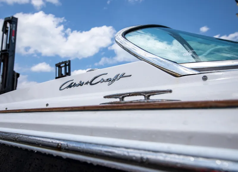 Slide: The Image of 2004 Chris-Craft Corsair 28 boat side view with logo and blue sky background. - 45