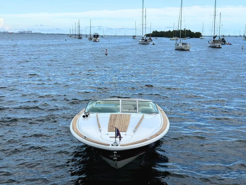 Slide: The Image of 2004 Chris-Craft Corsair 28 boat on calm waters with sailboats in the background. - 7