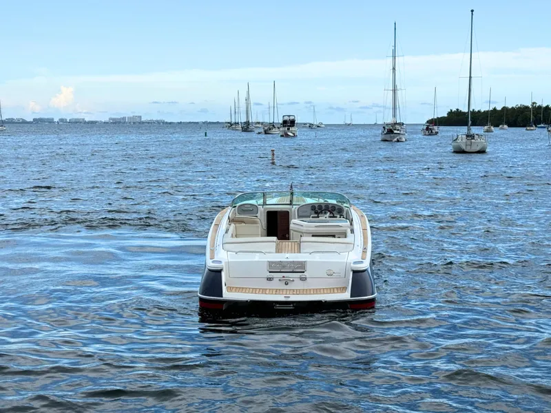 Slide: The Image of 2004 Chris-Craft Corsair 28 boat on open water with sailboats in the background. - 8